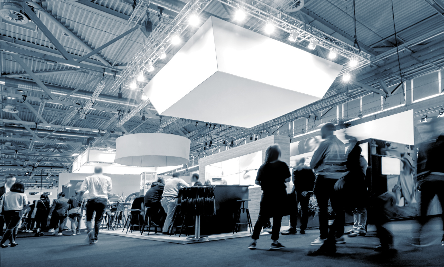 Business People Walking between Trade Show Booths at a Public Ev